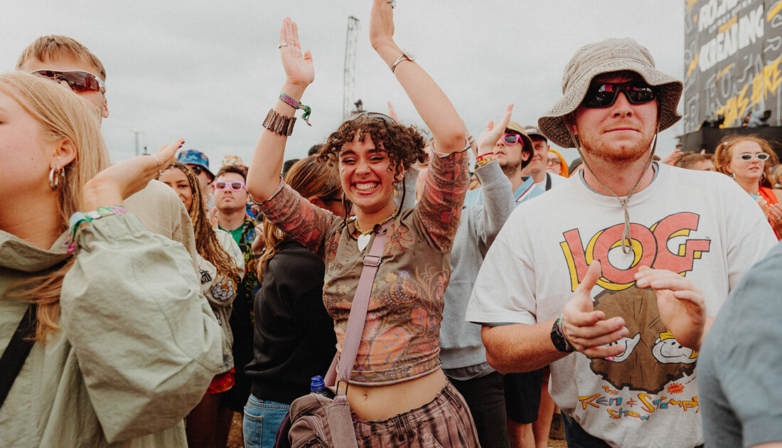 A lively crowd at a music festival, with people dancing and enjoying the music.