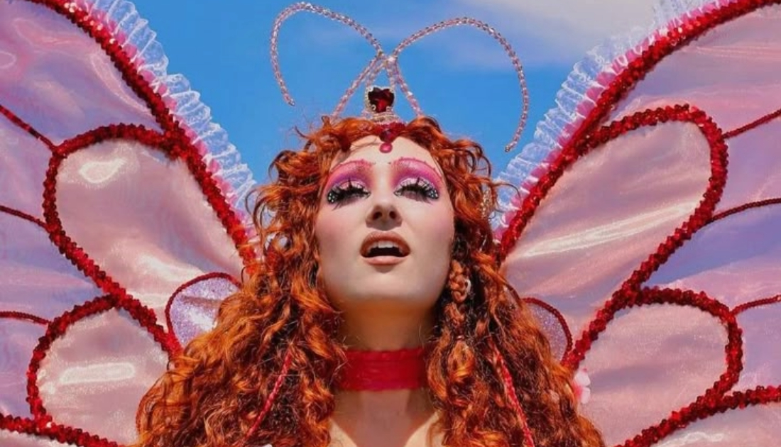 Chappell Roan wears a baby pink bodysuit lined with hot pink sequins with large detachable butterfly wings on stage at Coachella 2024 