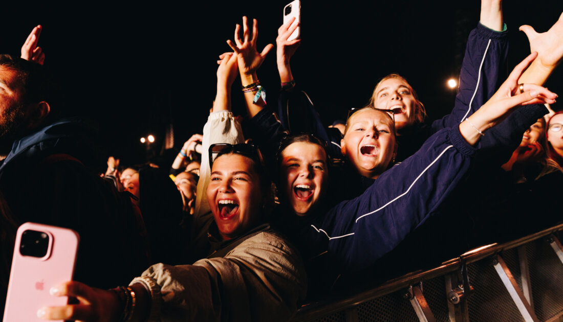 four female friends taking a selfie at the barrier while enjoying Reading Festival
