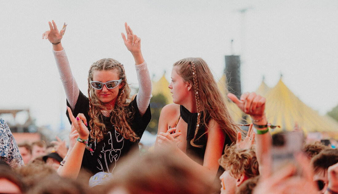 2 Fans raising arms while on their friends shoulders at Reading Festival
