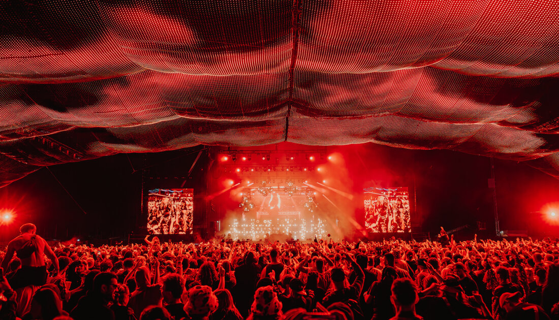 Fans under the orange lights of the Chevron Stage at Reading Festival